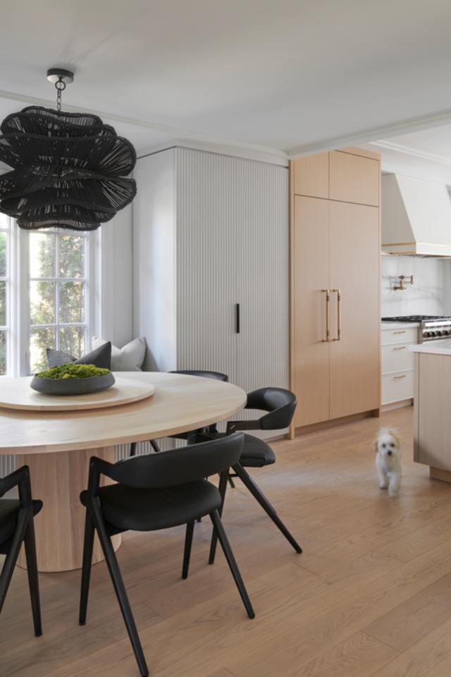 white and wood kitchen with breakfast nook with black chairs